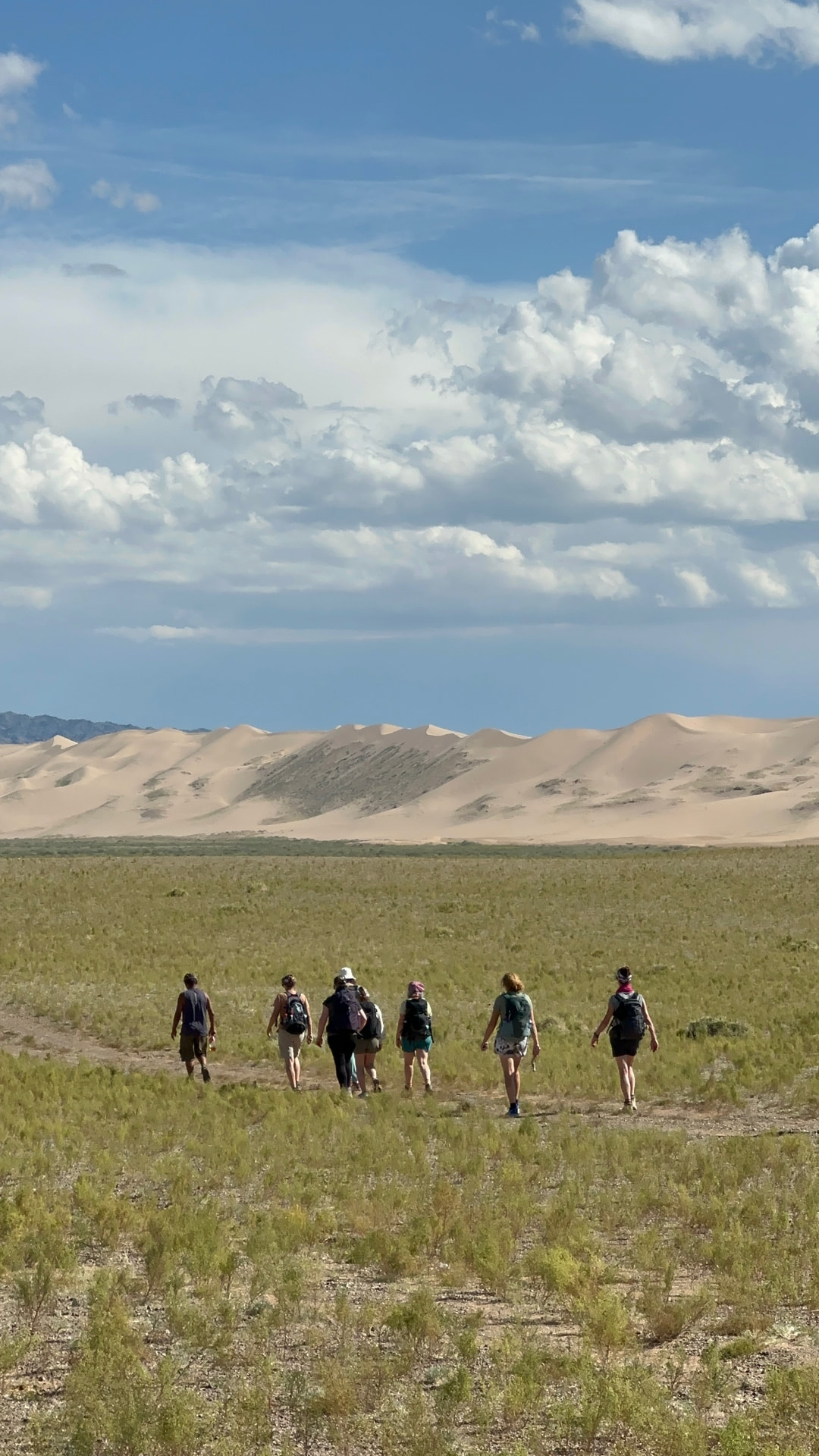 Retreat group walking across the scrub plain towards the dune ridge