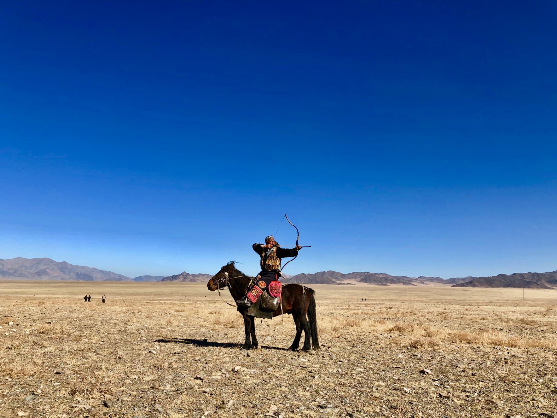 Mounted archer aiming his bow on the open Altai plain