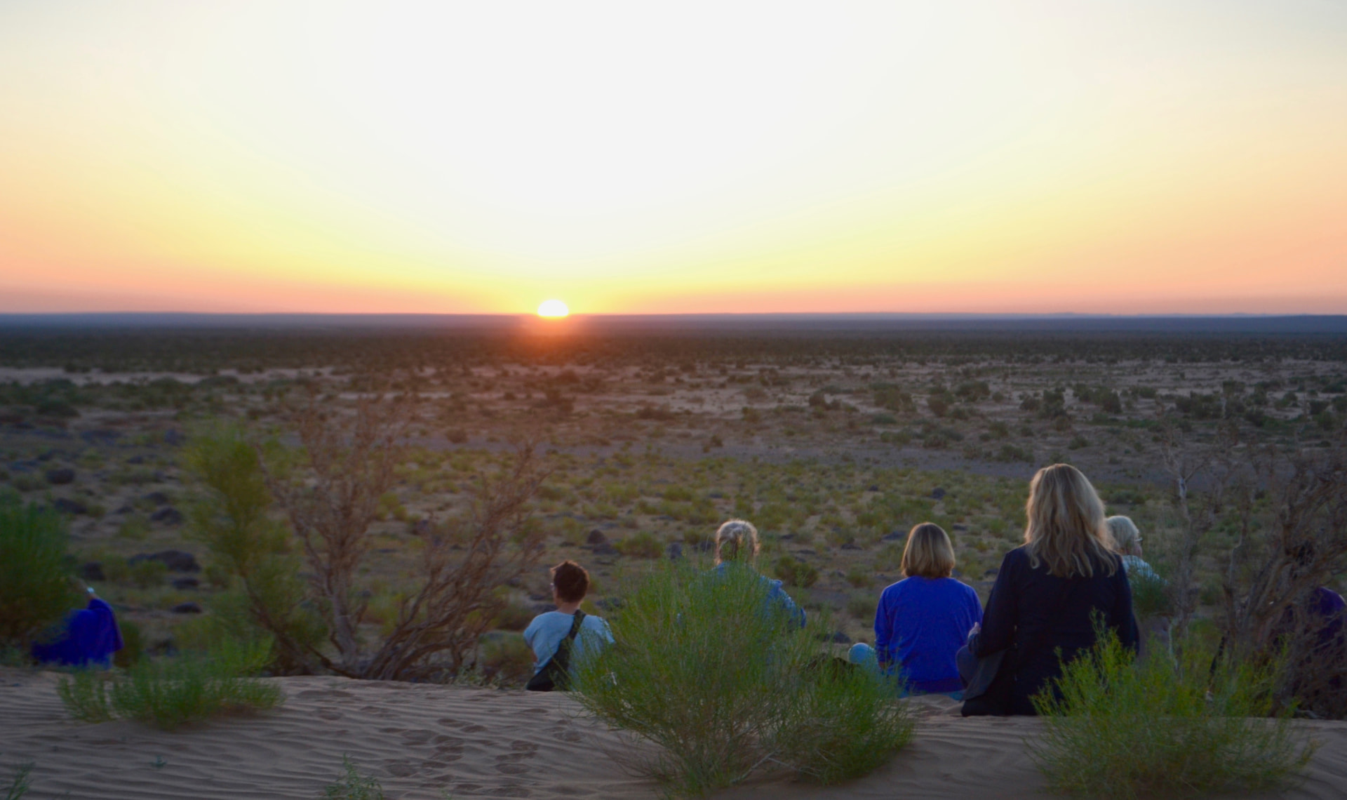 Retreat group sitting on the sand watching the Gobi sunset