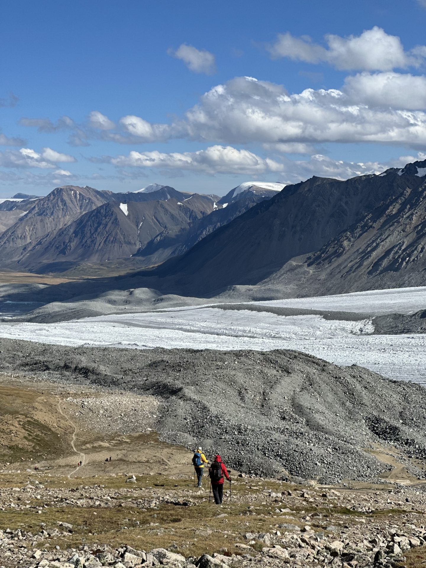 Hikers descending towards the Potanin glacier in the High Altai